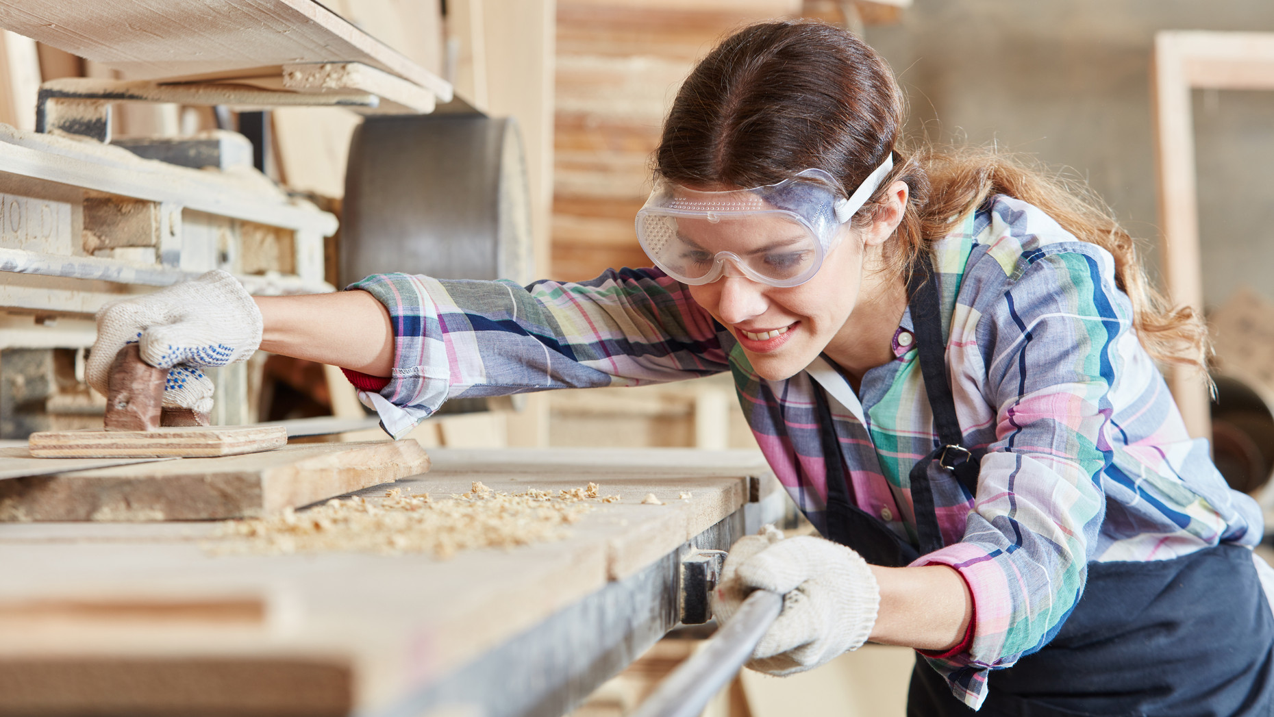 Tischlerin schleift Holz