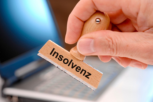 Hand mit Stempel mit der Aufschrift Insolvenz