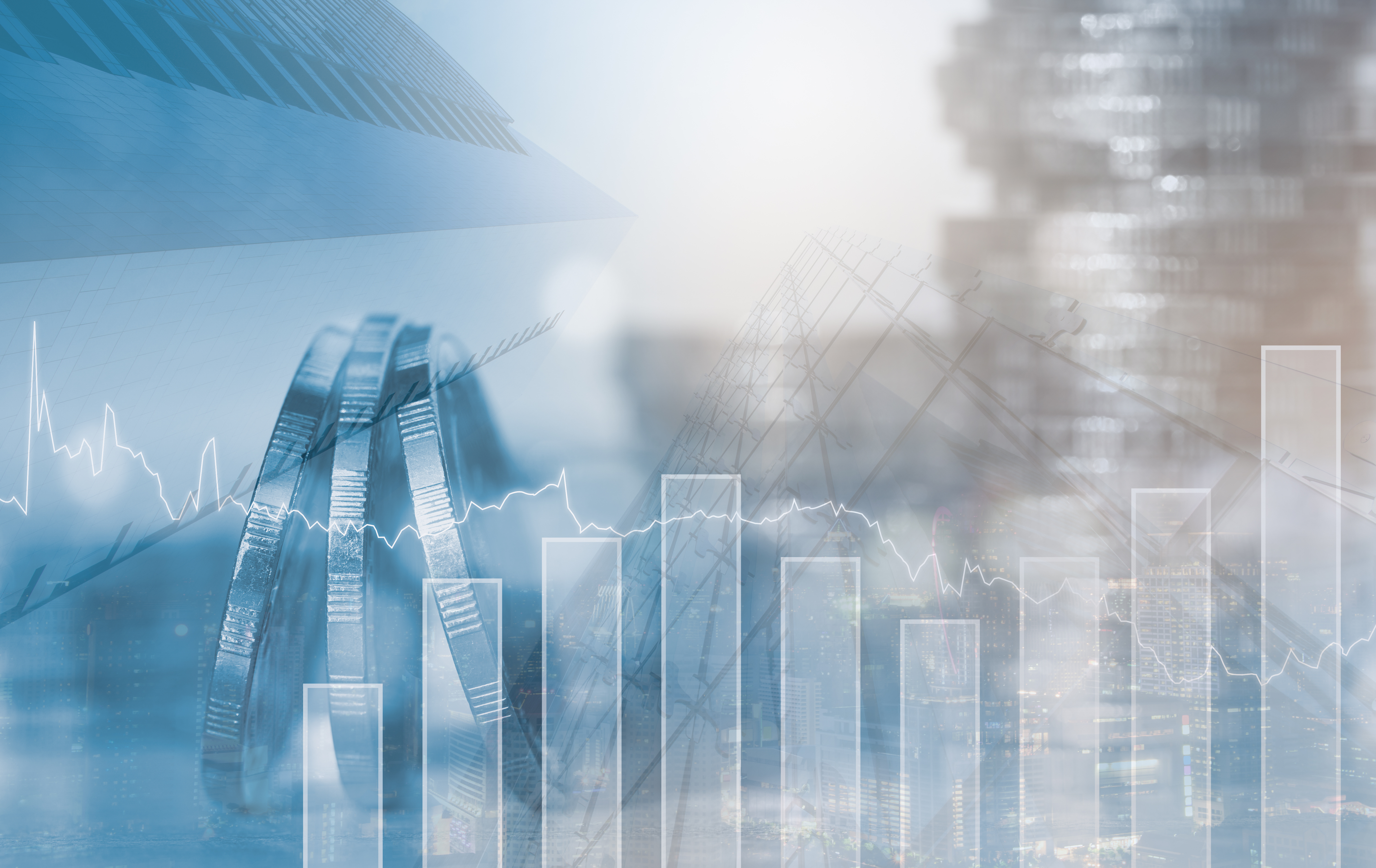 Im Vordergrund Linien- und Säulendiagramm, im Hintergrund sind unscharf Münzen und Geldstapel zu sehen